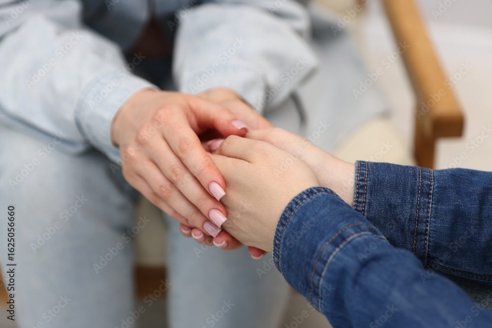 Obraz premium Friends holding hands after apology indoors, closeup