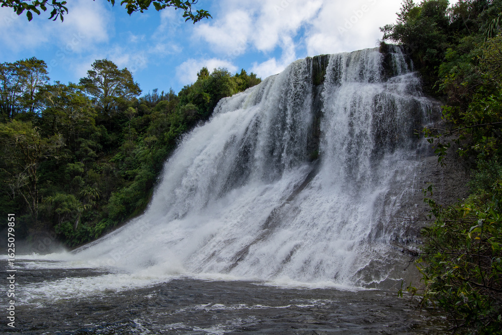 Fototapeta premium Majestic Waterfall Surrounded by Lush Greenery
