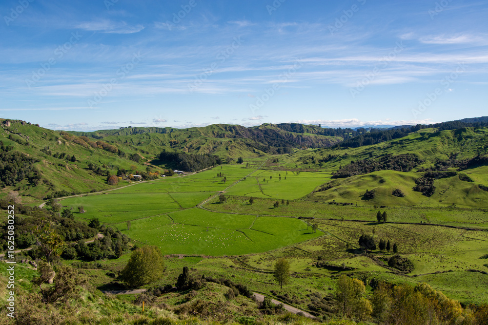 Obraz premium Lush Green Hills and Valleys Under Blue Sky