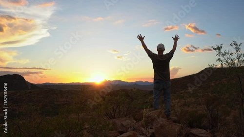 A man praising God from a scenic place at sunset