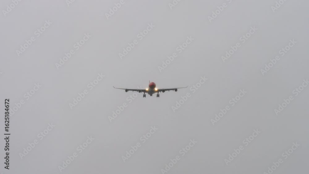 Jet passenger plane with unrecognizable livery approaching landing, long shot. Airplane flying in grey rainy sky. Travel concept, safe flights, aviation Jet passenger plane with unrecognizable livery approaching landing, long shot. Airplane flying in grey rainy sky. Travel concept, safe flights, aviation