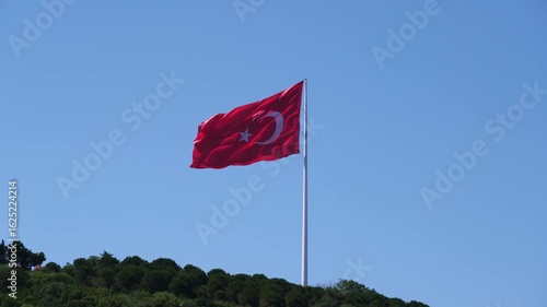 Turkish Flag Waving Proudly Atop a Hill in the Wind