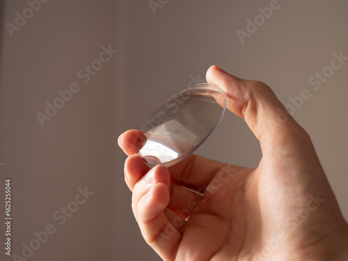 Obraz na płótnie hand holding round lens for eyeglass