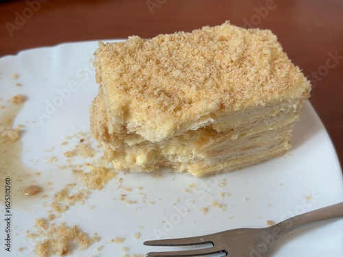 Close-up of Napoleon cake slice with bite on plate – dessert 