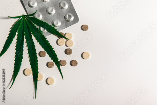 one cannabis leaf and pills on a light background. Alternative medicine