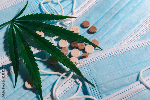 Large fresh medical cannabis leaf with medicines and medical masks