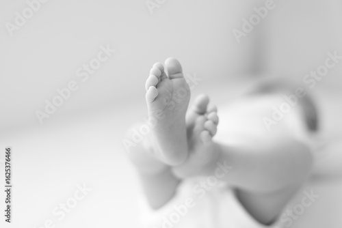 in focus the baby's feet, black and white