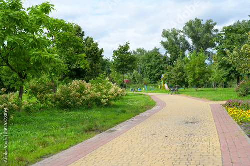 Wallpaper Mural Winding paved path leading to playground in a green park Torontodigital.ca