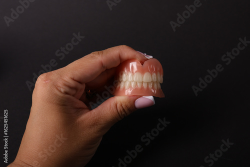 Full removable plastic denture of the jaws. Set of dentures on a white background. Two acrylic dentures. Upper and lower jaws with fake teeth. Dentures or false teeth, close-up. Copy space