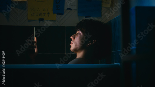 Tired And Stressed Man Lost In The Light Of The Smartphone