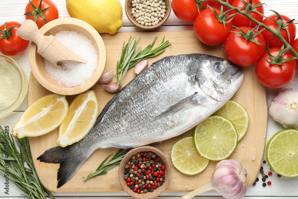 Fototapeta premium Fresh raw dourade with spices on white wooden table, flat lay. Fish and seafood delicacies