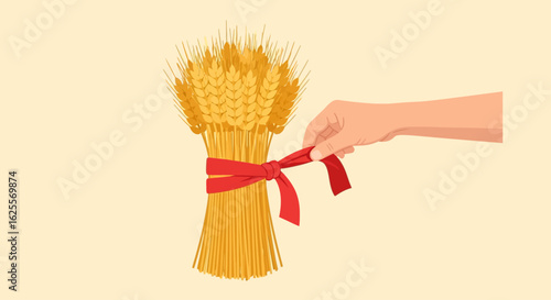 Hand tying a red ribbon around a sheaf of golden wheat stalks.
