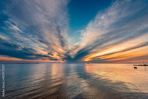 Sonnenunter- oder aufgang über dem norddeutschen Wattenmeer bei Flut oder Hochwasser am Strand von Utersum auf der Insel Föhr
