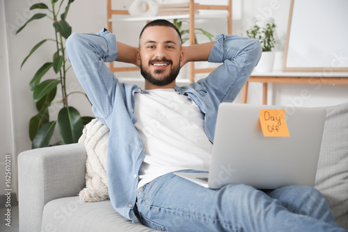 Young man with laptop resti...