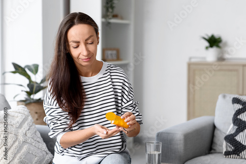 Woman taking medicine at home