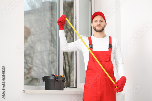 Male worker with tape measu...