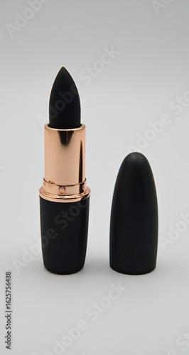 Black matte lipstick in a classic bullet tube shape with rose gold accents