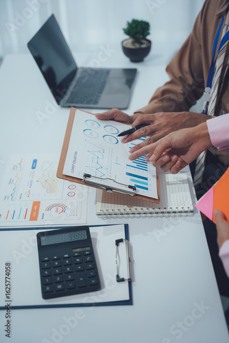 Business Consultation: Capturing the essence of collaboration as hands pore over graphs and charts in a professional setting, symbolizing strategic discussions.