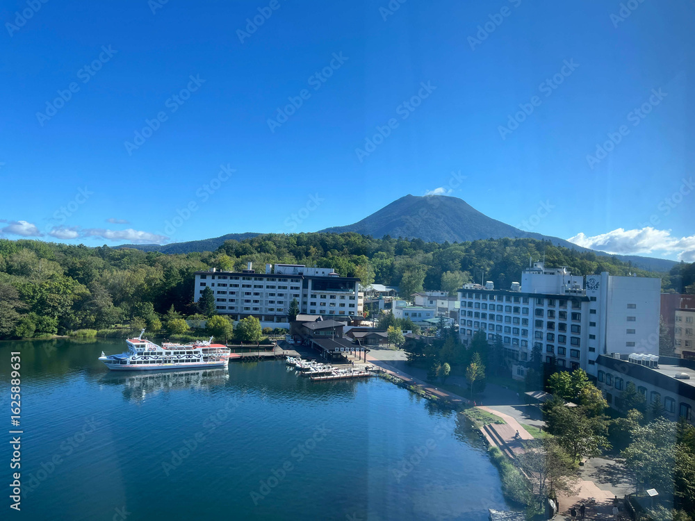 Fototapeta premium 湖畔の観光ホテルと野山