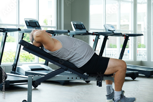 An overweight man exercises at the gym as part of his weight loss workout.
