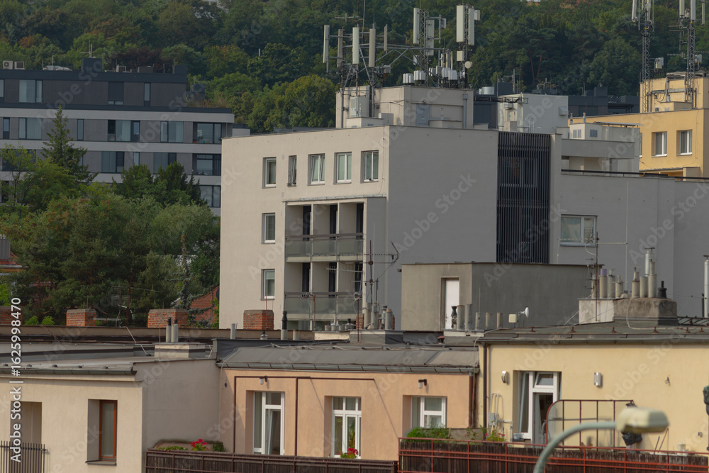 Fototapeta premium A row of tall buildings featuring antennas installed on the rooftops, showcasing modern urban architecture and design elements