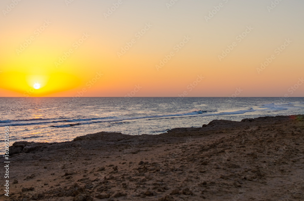 Obraz premium Golden sunset with calm waves and sandy coastline in Egypt 2 March 2025