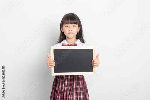 Obraz na płótnie A Chinese primary school student holding a small blackboard.