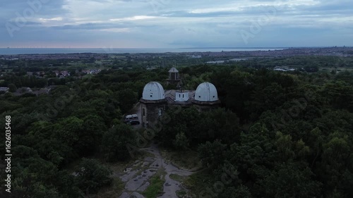 4k Aerial view of old observatory amongst lush green trees
