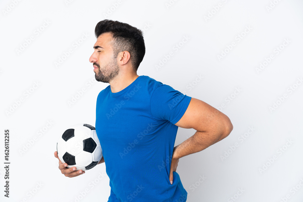 Handsome young football player man over isolated wall suffering from backache for having made an effort Handsome young football player man over isolated wall suffering from backache for having made an effort