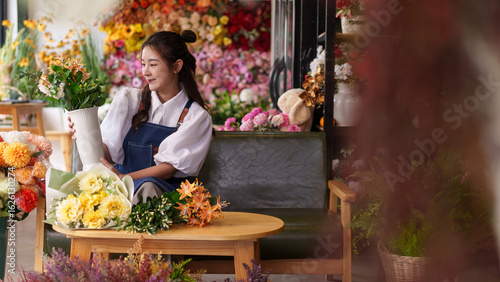 Bild auf Leinwand Asian woman small business owner carefully arranging beautiful artificial flower