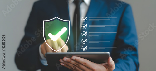 Data Protection and Security: A professional in a dark suit uses a digital tablet to assess and maintain robust data protection and security protocols.