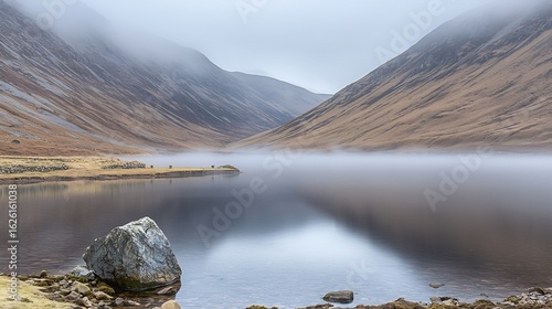 Dense fog rolling over a quiet lake at dawn with the mist gently touching the waters surface creating a serene and mysterious atmosphere