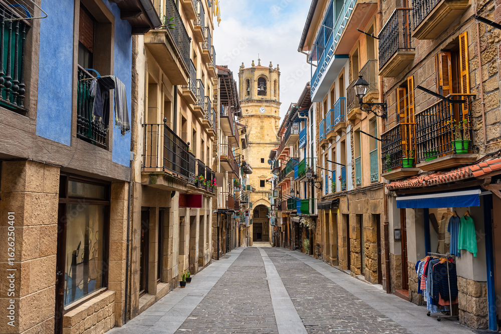 Obraz premium Main street of the historic center of Getaria with old buildings and the church of San Salvador at the end of the street, Basque Country