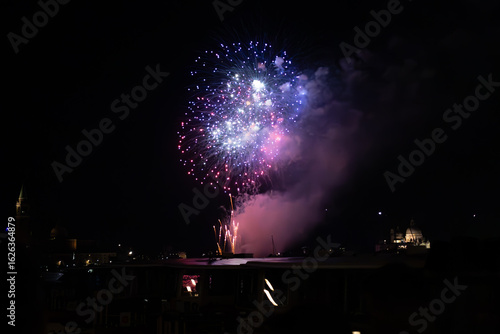 A photo of a fireworks is lit up the night sky