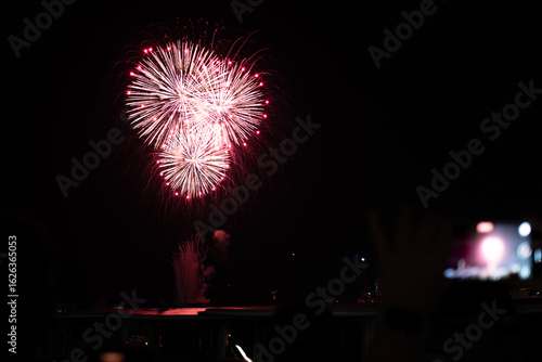 A photo of a person sitting at a table watching a fireworks