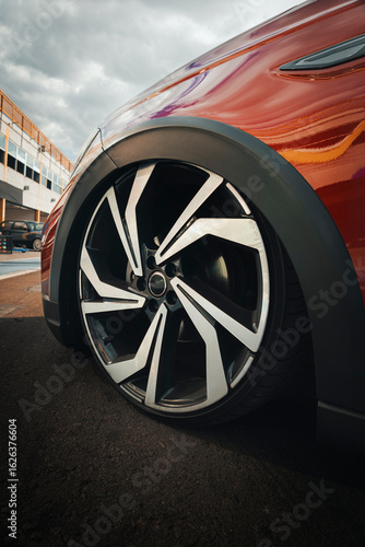 Fotografía Multi spoke alloy automotive wheel with diamond cut finish, mounted on a low profile tire, highlighting the lowered suspension and fitting flush with the fender