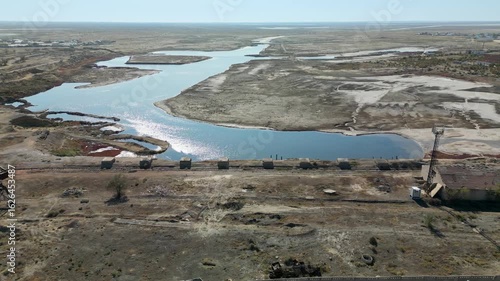 Aerial view of Aralsk’s former port. Rusted cranes and old rail tracks are near the dried seabed and a narrow canal — the remnants of a once-bustling fishing hub.
Aral sea seen on the horizon
