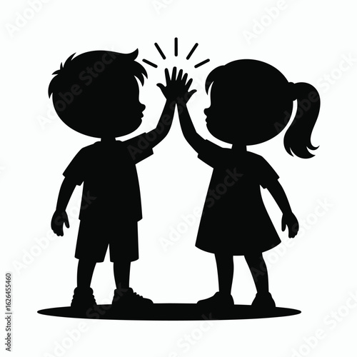 Two happy children silhouetted giving each other a high five celebration