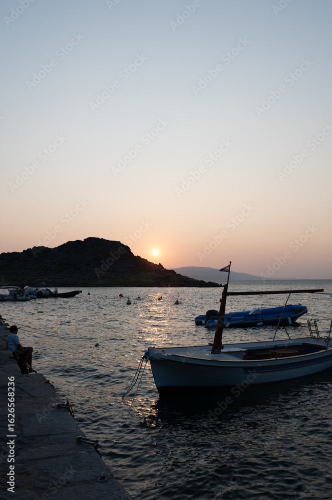 Fototapeta premium Sunset with boats and an island by the sea