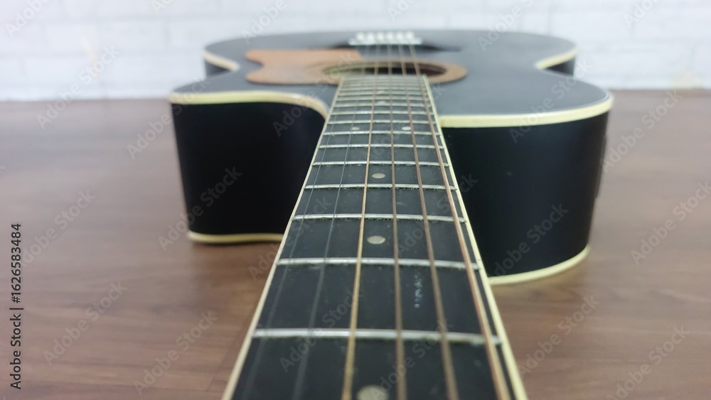 Obraz premium an elegant black acoustic guitar made of rosewood, with six steel strings that produce a melodious sound.