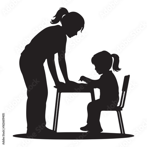 Silhouette of teacher helping student at desk learning