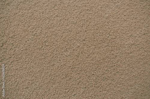 Sandy brown textured background with small grains