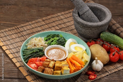 Gado-gado is a food consisting of vegetables, potatoes, tempeh, tofu, boiled eggs, etc. seasoned with peanut sauce and so on.