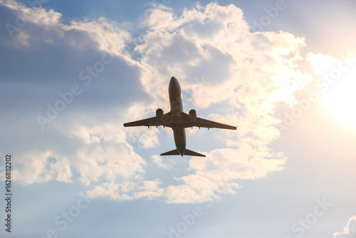 Airplane flying against a backdrop of clouds during sunset in the evening sky