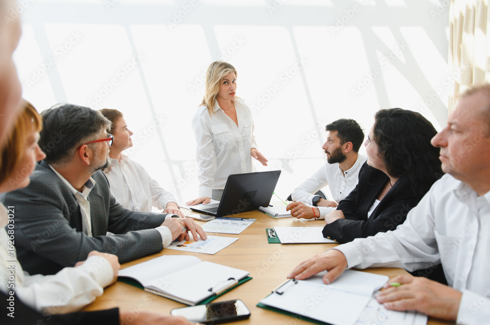 Business team meeting with female leader discussing strategy in modern office Business team meeting with female leader discussing strategy in modern office