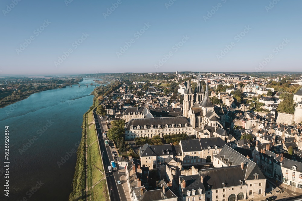 Fototapeta premium An elevated perspective overlooking the charming Chaumont-sur-Loire, France. The Loire River flows past the city, with the magnificent Chateau de Chaumont rising above the rooftops