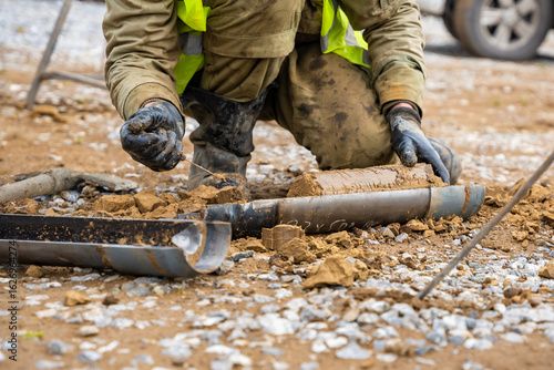 Man cutting and cleaning soil sample for laboratory analysis. Preparation of core material for geotechnical testing and scientific evaluatio