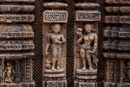 A close-up view of detailed stone carvings on the wall of Konark sun temple, an ancient temple.