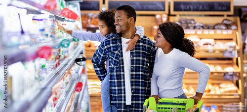 Canvastavla Portrait of happy black family with trolley shopping together at grocery store