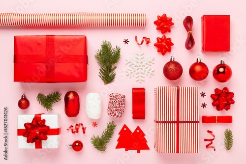 Handmade wrapped christmas gift boxes with stuff on color background, top view